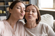 © fizkes - Vlogger women using smartphone recording new video vlog, faces of middle-aged mother and grown up adult daughter looking at camera blowing kisses pouting lips making selfie photo, webcam close up view