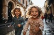 © Rafa - very happy boy and girl while playing on a street with soap bubbles