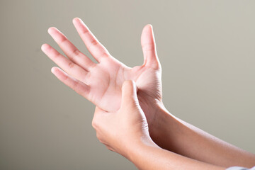 Wall Mural - Hand pain acupressure on grey background