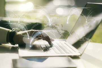 Wall Mural - double exposure of abstract digital world map with connections and hands typing on laptop on backgro