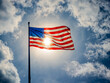 american flag against blue sky und sunlight