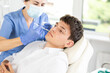 © JackF - Young man having face mesotherapy implemented by middle-aged dermatologist in aesthetic clinic