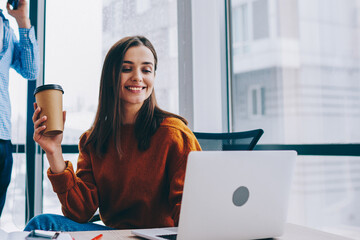 Wall Mural - happy woman reading good news via laptop while male colleague talking on smartphone