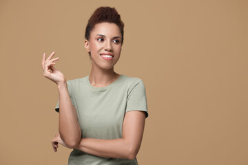 Poster - Portrait of beautiful young woman on light brown background. Space for text