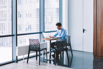 Wall Mural - millennial male programmer working remotely at desktop with modern laptop computer