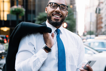 Wall Mural - Black businessman using cellphone on street