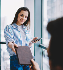 Wall Mural - half length portrait of cheerful female entrepreneur with cute smile on face taking textbook