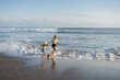 © Julija - Mother with daughter have fun at beach with black sand in Bali, running at waves, enjoy life and traveling