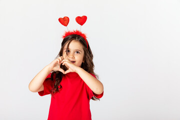 Smiling happy little girl in red t-shirt and headband with two red hearts celebrating Valentine's day on white. children's holiday card, gift for Mother's day, Father's day, hobby, crafts concept.