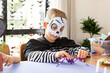 © Виктория Попова - A cute boy in a carnival costume makes a funny spider with his own hands for Halloween.