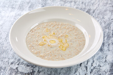 Bowl with tasty oatmeal with butter