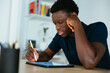 © Westend61 - Young student studying and writing on tablet PC at desk