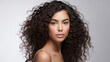 © Malambo/Peopleimages - AI - Portrait of young woman with dark natural curly hair. Hair care, make-up and hair health