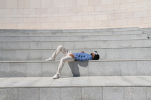 Carefree Man Wearing Virtual Reality Simulator And Lying Down On Steps