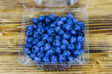 Wall Mural - Blueberry in plastic box on a wooden table