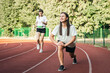 © puhimec - A young woman runner in start position on running track while work out.