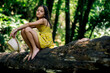 © ADDICTIVE STOCK - Pensive preteen girl sitting on tree trunk in nature