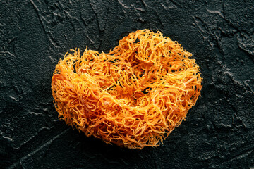 Wall Mural - Irish sea moss, heart-shaped. Chondrus Crispus, healthy organic raw seaweed, a close-up on a black background