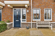 © ADDICTIVE STOCK - Exterior of brick house with blue front door