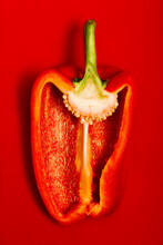 Ripe Shiny Sliced Pepper On Red Surface