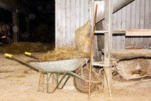 Wheelbarrow With Hay And Dirty Wheel In Barn