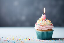 Gray Background With Copyspace Birthday Cupcake And A Single Candle Sprinkled With Pastel Colors