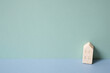 Miniature wood model house on mint blue background. rental, buy, real estate concept