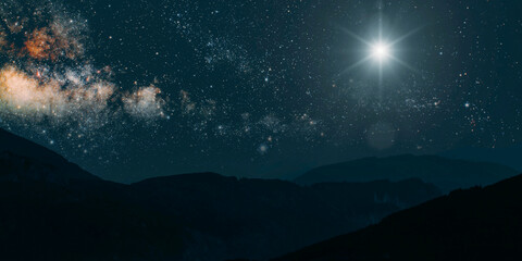 Wall Mural - a Christmas star shines at night over the mountains of Bethlehem