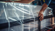 A close-up of a worker securing boxes with plastic wrap on a pallet, ensuring safe and stable transportation. 