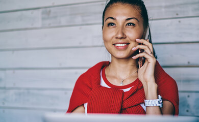 Wall Mural - Smiling ethnic woman chatting on cellphone