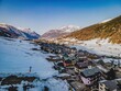 A breathtaking aerial perspective of Livigno, captured with precision from a drone. The sprawling town, nestled amidst the majestic Alps.