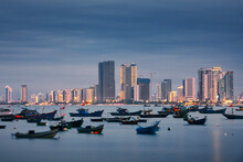 Da Nang Cityscape At Twilight. Fishing Boat Moored In Port Against Illuminated Coast With Modern Buildings..