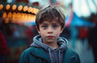 Upset 7 year old child at an amusement park, blurry background