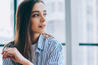 © BullRun - Dreamy lady looking away in office