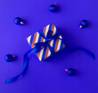 canvas print picture - Christmas gift wrapped in striped paper on the blue background. Close-up.Top view.