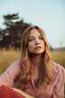 © Marko Geber - Portrait of a young beautiful woman on a field in nature