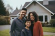 © Baba Images - Portrait of a happy young family in front of a house