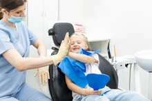 Little Patient Girl Sitting In A Chair Gives A High Five To A Pediatric Dentist After Dental Treatment At A Clinic With Modern Equipment. Concept Of Modern And Painless Treatment Of Children's Teeth.