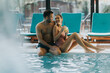 © BGStock72 - Young couple relaxing by the indoor swimming pool