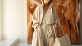 Fototapeta  - Young woman wearing soft beige clothing with tote bag in style of New-Age Minimalism or Quiet Luxury style