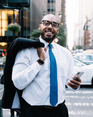 Wall Mural - Black businessman using cellphone on street