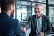 © Danny - Smiling middle aged businessman handshaking partner making partnership collaboration agreement at office meeting.