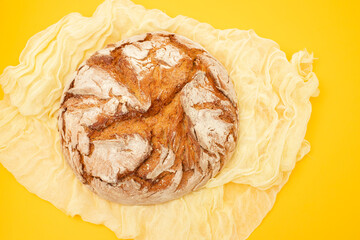 Wall Mural - freshly baked bread loaf on yellow napkin