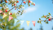 string of colorful pennant against blue sky in the garden as a summer party decoration