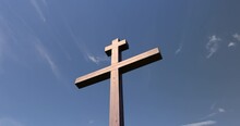 Wooden Christian Cross On A Blue Sky Background, Wooden Orthodox Cross On A Sky Background With Clouds