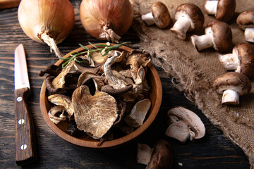 dried wild organic mushroom on dark table background. Autumn food. Top view.