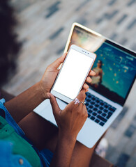 Back view of woman looking to smartphone screen while using technology
