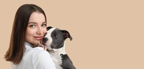 Young girl holding cute puppy on beige background with space for text