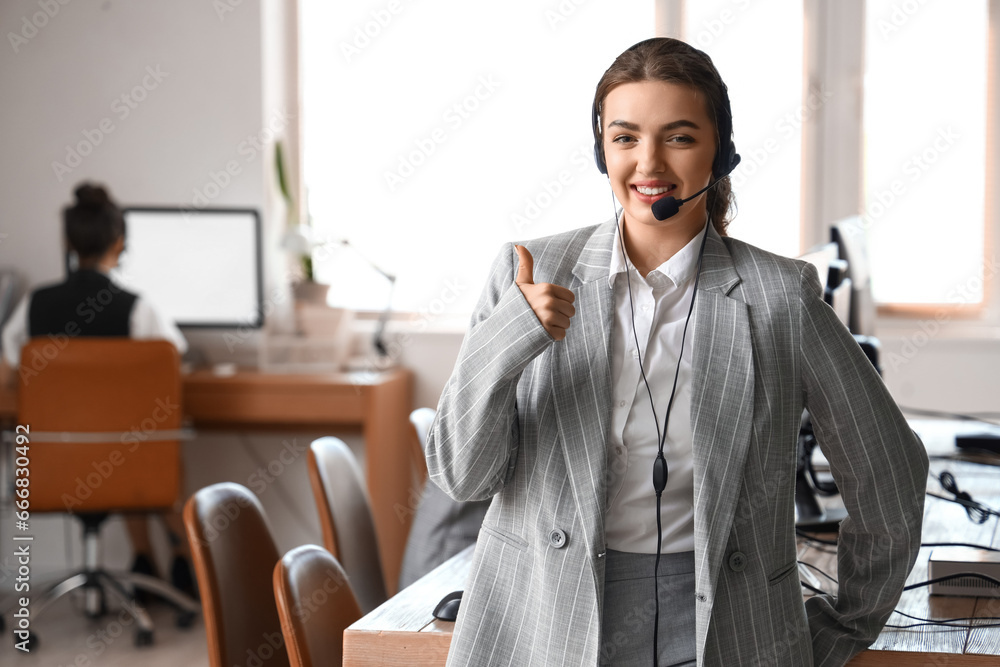 Female technical support agent showing thumb-up in  office