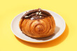 Plate of sweet croissant with chocolate on orange background